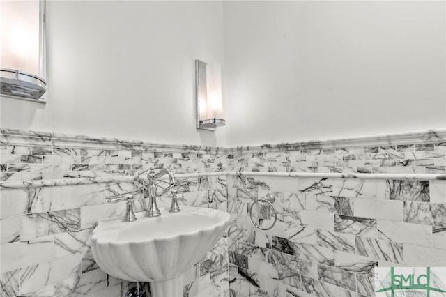 bathroom with sink and tile walls