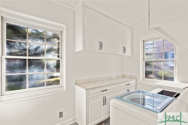 interior space with ornamental molding, washer / clothes dryer, and cabinets