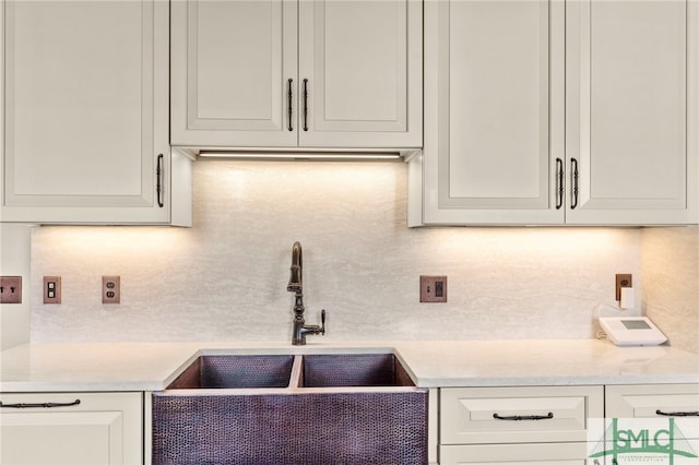 kitchen with sink, white cabinetry, and decorative backsplash