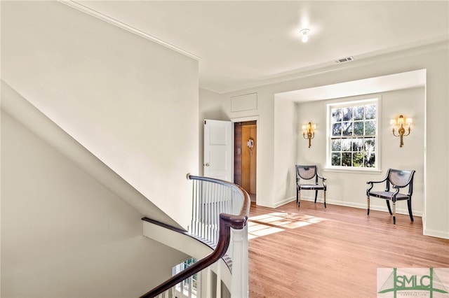 living area with crown molding and light hardwood / wood-style floors