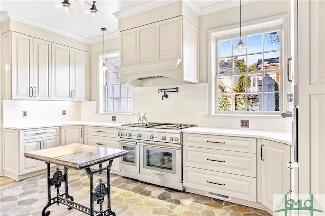 kitchen with pendant lighting, range with two ovens, white cabinets, and decorative backsplash