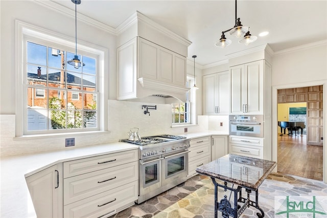 kitchen featuring decorative light fixtures, appliances with stainless steel finishes, light hardwood / wood-style flooring, and white cabinetry