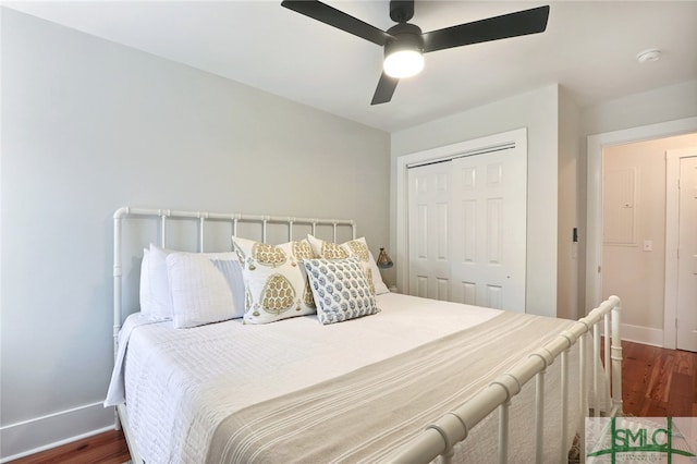 bedroom with ceiling fan, a closet, and dark wood-type flooring