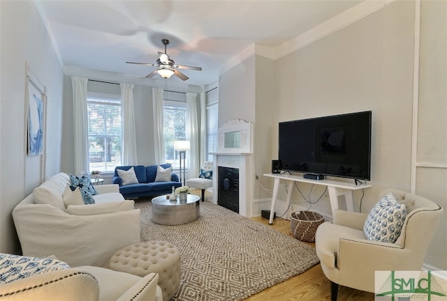 living room featuring crown molding, ceiling fan, and light wood-type flooring