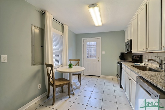 kitchen with tasteful backsplash, white cabinetry, light tile floors, stainless steel appliances, and light stone countertops