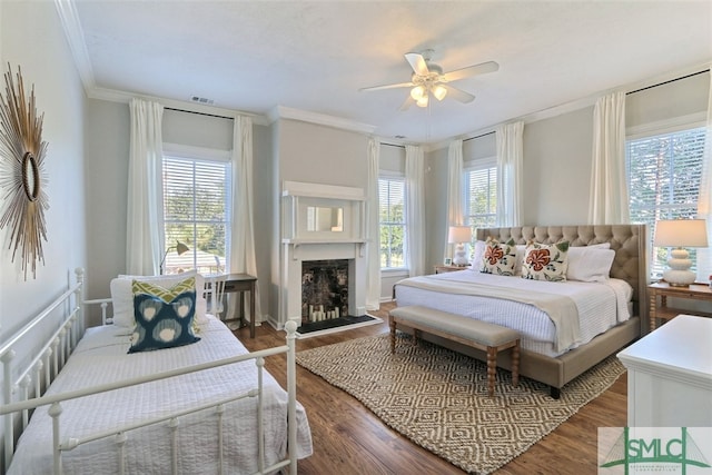 bedroom with ceiling fan, ornamental molding, and dark hardwood / wood-style floors