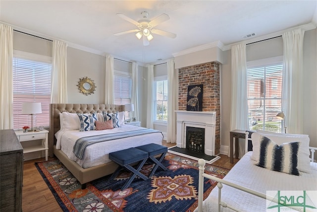 bedroom featuring ceiling fan, crown molding, dark wood-type flooring, and brick wall