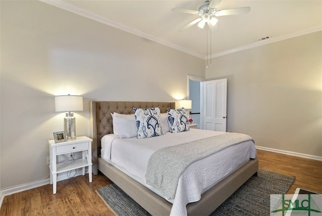 bedroom with ornamental molding, ceiling fan, and dark hardwood / wood-style flooring