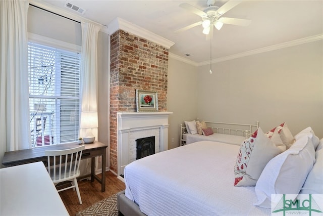 bedroom featuring dark wood-type flooring, ceiling fan, a fireplace, brick wall, and crown molding