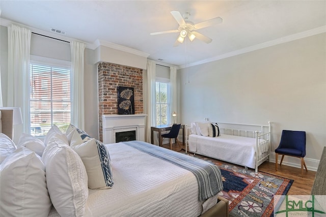 bedroom with brick wall, hardwood / wood-style floors, ornamental molding, and ceiling fan