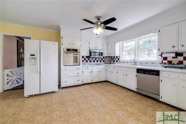 kitchen with appliances with stainless steel finishes, white cabinetry, light tile floors, ceiling fan, and sink