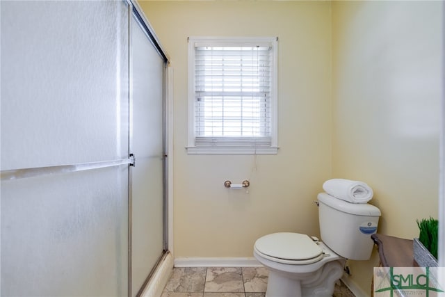 bathroom with toilet, tile flooring, and a shower with door