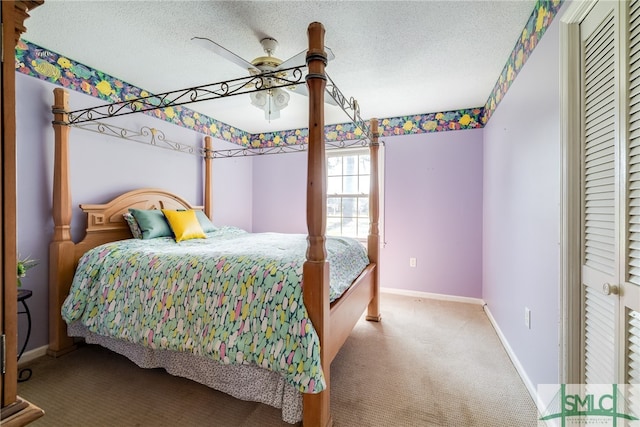 carpeted bedroom featuring ceiling fan, a textured ceiling, and a closet