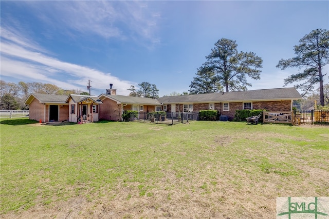 rear view of house featuring a yard