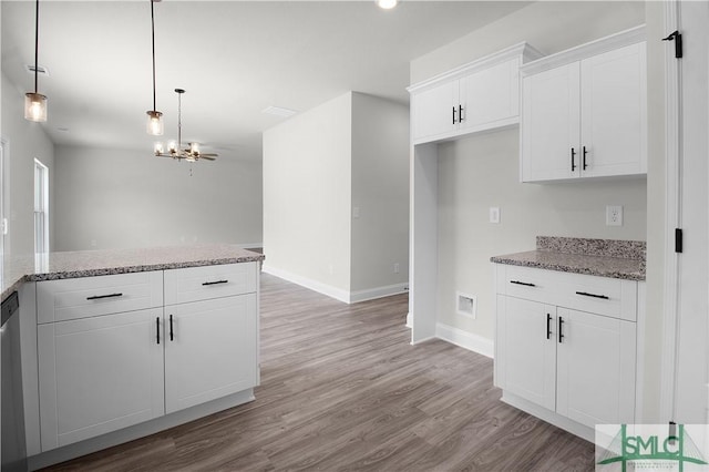 kitchen featuring baseboards, light wood finished floors, white cabinetry, and light stone countertops