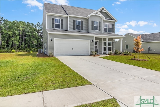 view of front of property with cooling unit, a garage, and a front lawn