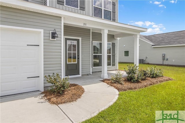 property entrance featuring a porch, a lawn, and central AC unit