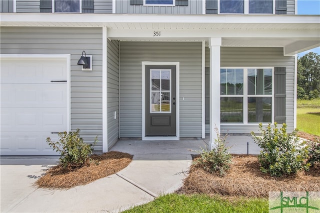 entrance to property with covered porch and a garage