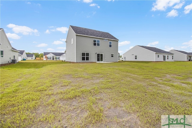 rear view of house featuring a lawn and central air condition unit