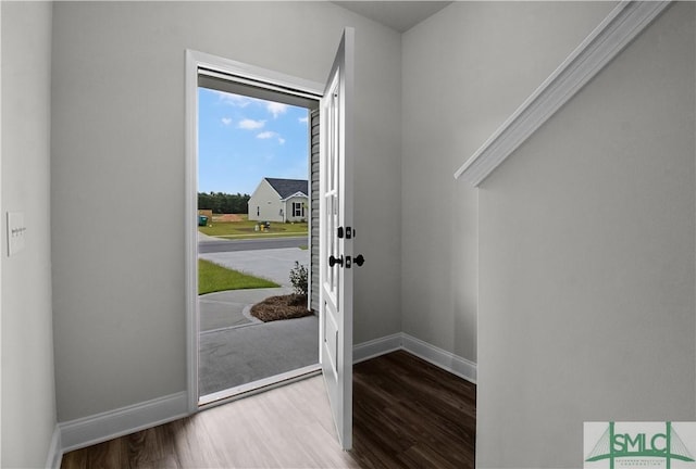 foyer entrance with baseboards and wood finished floors