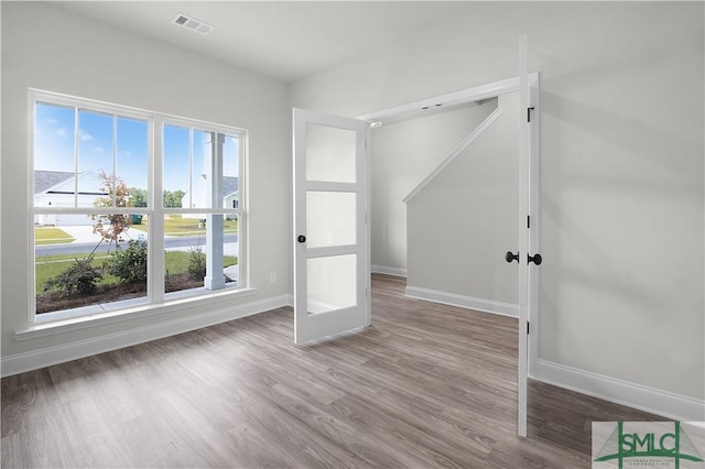 interior space with wood finished floors, visible vents, and baseboards