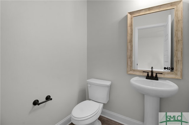 bathroom with toilet and wood-type flooring