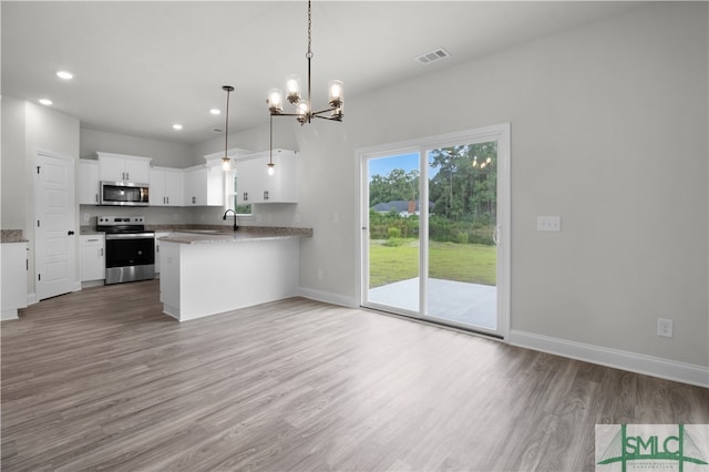 kitchen with hanging light fixtures, white cabinetry, light hardwood / wood-style floors, kitchen peninsula, and stove