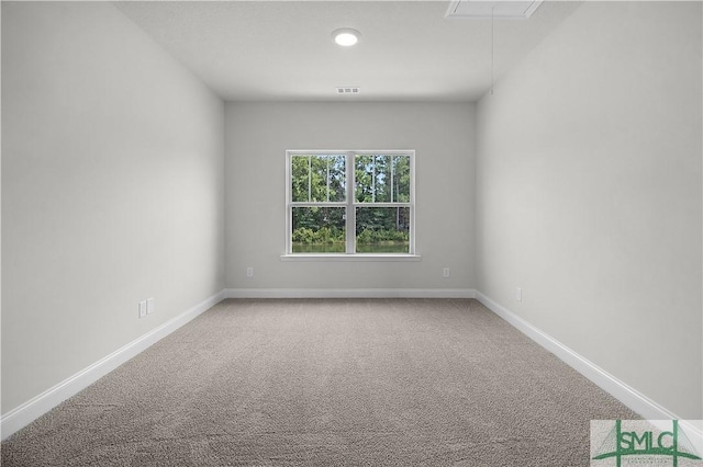 unfurnished room featuring baseboards, attic access, visible vents, and carpet flooring