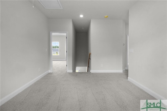 spare room with recessed lighting, carpet, attic access, and baseboards