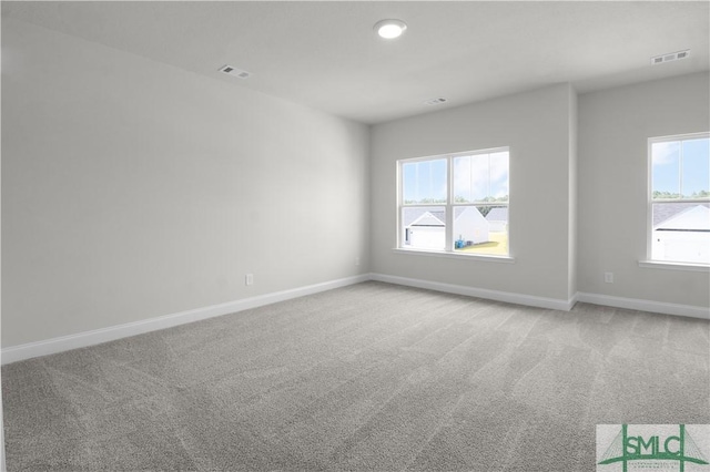 empty room featuring carpet flooring, visible vents, and baseboards