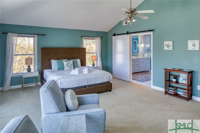 carpeted bedroom featuring a barn door, connected bathroom, lofted ceiling, and ceiling fan