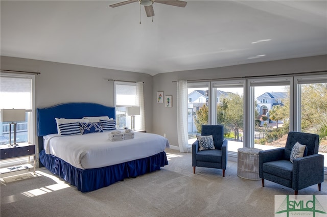 bedroom with ceiling fan, light carpet, and multiple windows