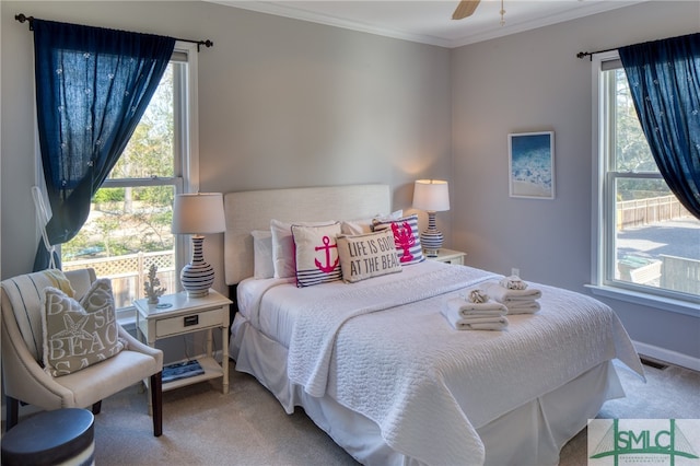 carpeted bedroom with ceiling fan and crown molding