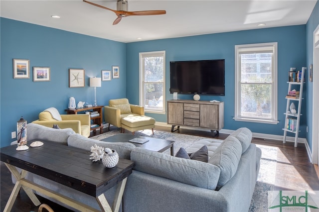 living room featuring dark hardwood / wood-style flooring, ceiling fan, and a healthy amount of sunlight