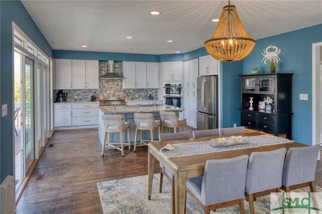 dining space with an inviting chandelier, dark wood-type flooring, and sink