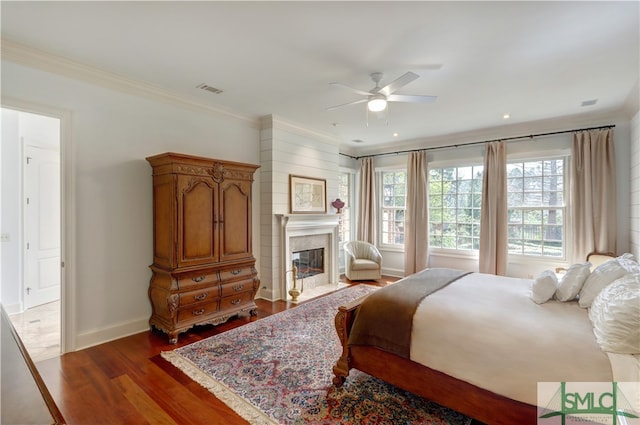 bedroom with dark hardwood / wood-style floors, ceiling fan, and ornamental molding