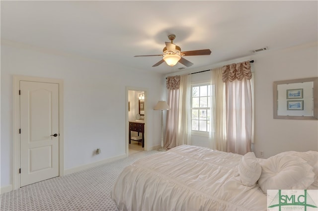 bedroom featuring ensuite bath, light colored carpet, and ceiling fan