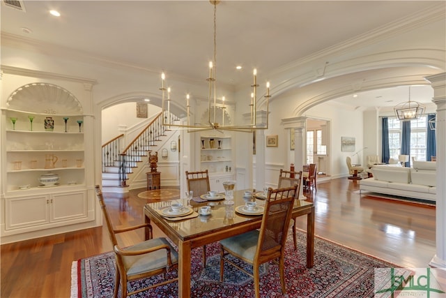 dining area featuring hardwood / wood-style floors, crown molding, and an inviting chandelier