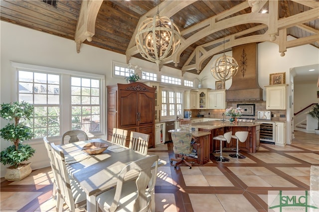 tiled dining area with wooden ceiling, high vaulted ceiling, a chandelier, and beverage cooler