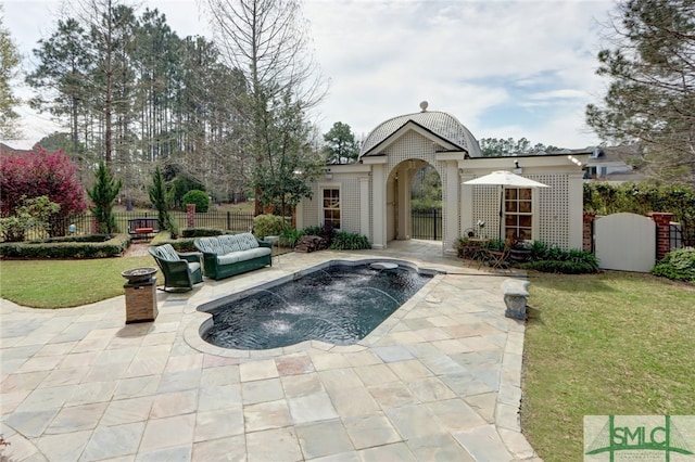 view of swimming pool featuring pool water feature, an outdoor structure, a patio, and a lawn