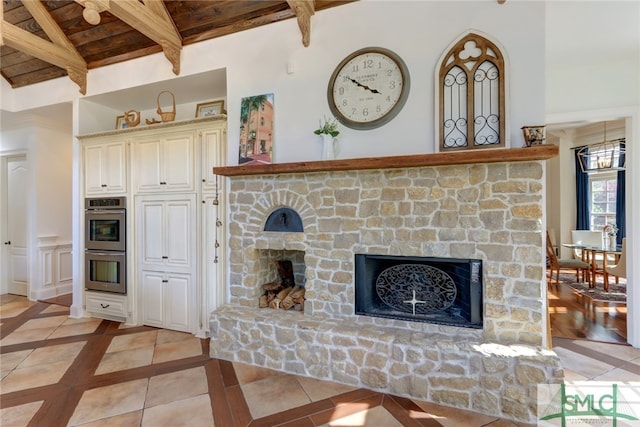 tiled living room featuring wood ceiling, beamed ceiling, and a fireplace