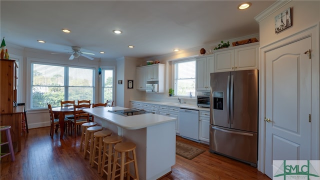 kitchen featuring stainless steel fridge, a center island, dishwasher, and white cabinetry
