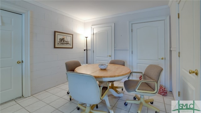 dining space featuring crown molding and light tile floors