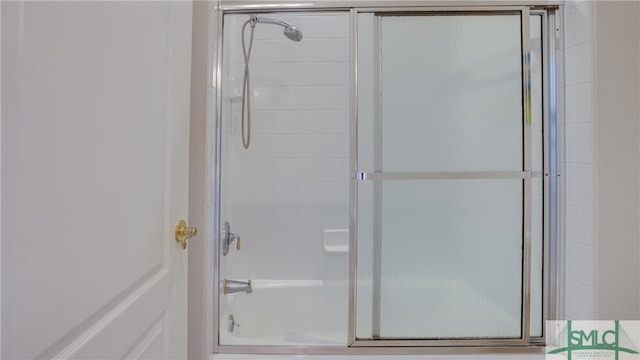 bathroom with bath / shower combo with glass door