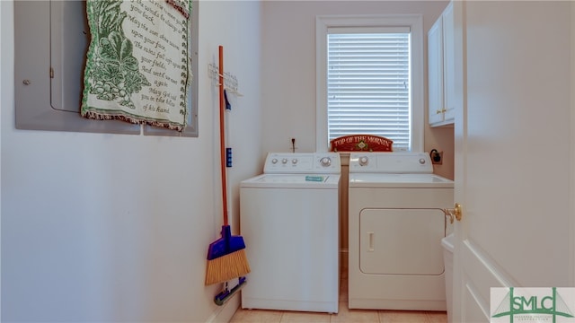 clothes washing area featuring light tile flooring, independent washer and dryer, and cabinets