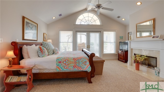 bedroom with ceiling fan, high vaulted ceiling, a tile fireplace, and light colored carpet
