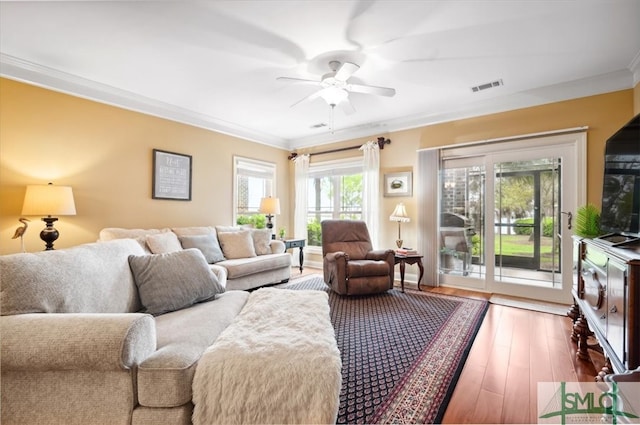 living room featuring hardwood / wood-style floors, ceiling fan, and ornamental molding