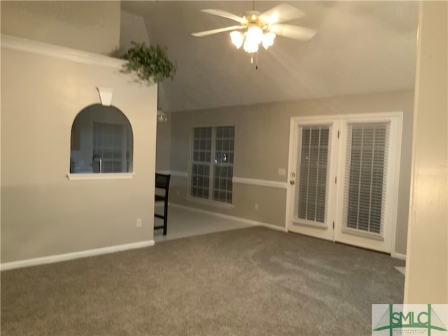 carpeted spare room with ceiling fan and vaulted ceiling