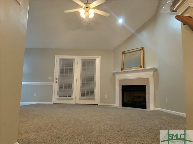 unfurnished living room featuring a tiled fireplace, lofted ceiling, carpet, and ceiling fan