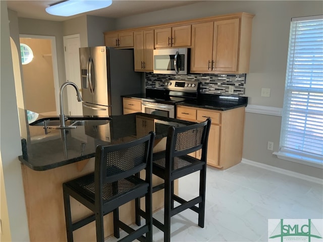 kitchen with stainless steel appliances, light tile floors, tasteful backsplash, dark stone countertops, and sink